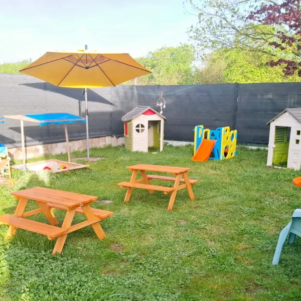 Le jardin de la crèche avec ses tables et sa cabane